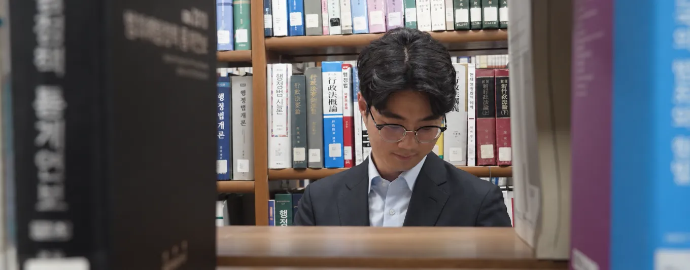서가 사이에서 책을 읽는 손호영 판사